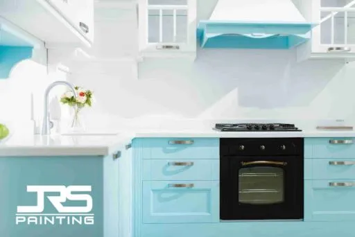 Two-tone kitchen cabinets with painted blue lowers and white uppers, featured in a cabinet painting durability guide for wear resistance.