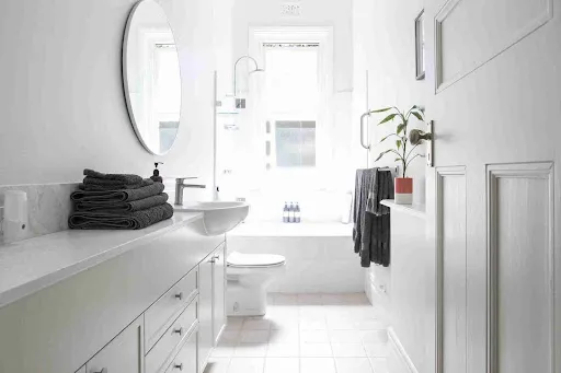 How to Paint a Bathroom: Step-by-Step Pro Guide A bathroom painting guide for a finished white bathroom with vanity, mirror, and tub