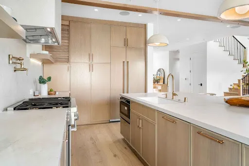 Contemporary kitchen with refinished wood cabinets and island, highlighting cabinet refinishing for kitchens and bathrooms.