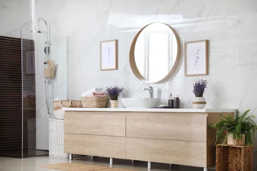 Modern bathroom vanity with light wood finish, showcasing cabinet refinishing for kitchens and bathrooms.