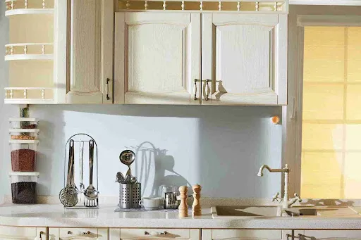 Modern white kitchen cabinets and wood backsplash highlight the updated look that proves cabinet painting is worth it.