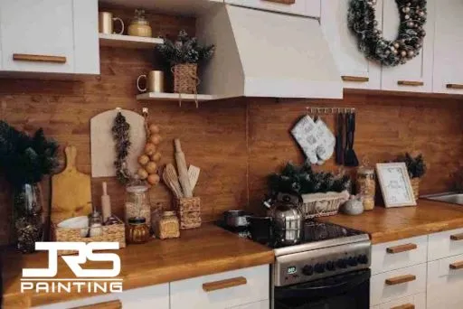 Cabinet Painting for Older Kitchens: Is It Worth It? Modern white cabinets with wood backsplash illustrate design upgrades tied to Is Cabinet Painting worth it.