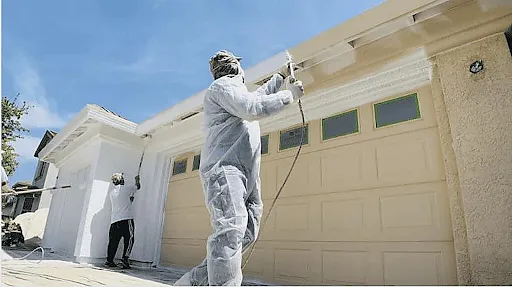 Professional painters working on a house during the best time to paint home exterior in Arizona.