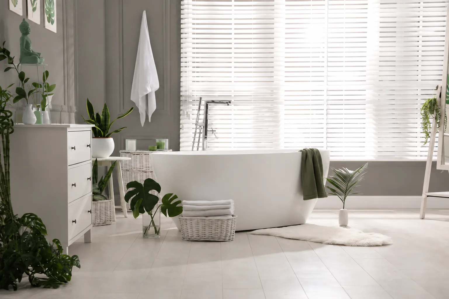 benjamin-moore-chelsea-gray-bathroom-paint-color Bathroom painted in Benjamin Moore Chelsea Gray with white tub, bright natural light, and green accents